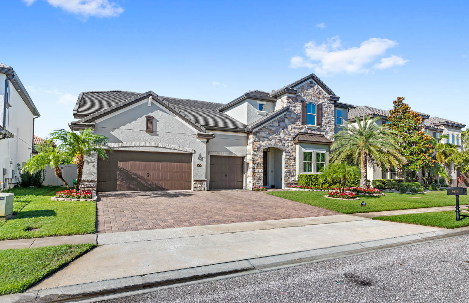 front of two story home with three car garage and brown brick design